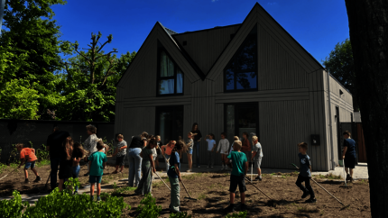 Twee woningen aan de Abtshof waar leerlingen aan het werk zijn in de voortuin